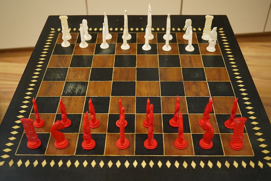 A Sri Lankan chess table and a boxed bone chess set, table measures 62cm high. Condition - good